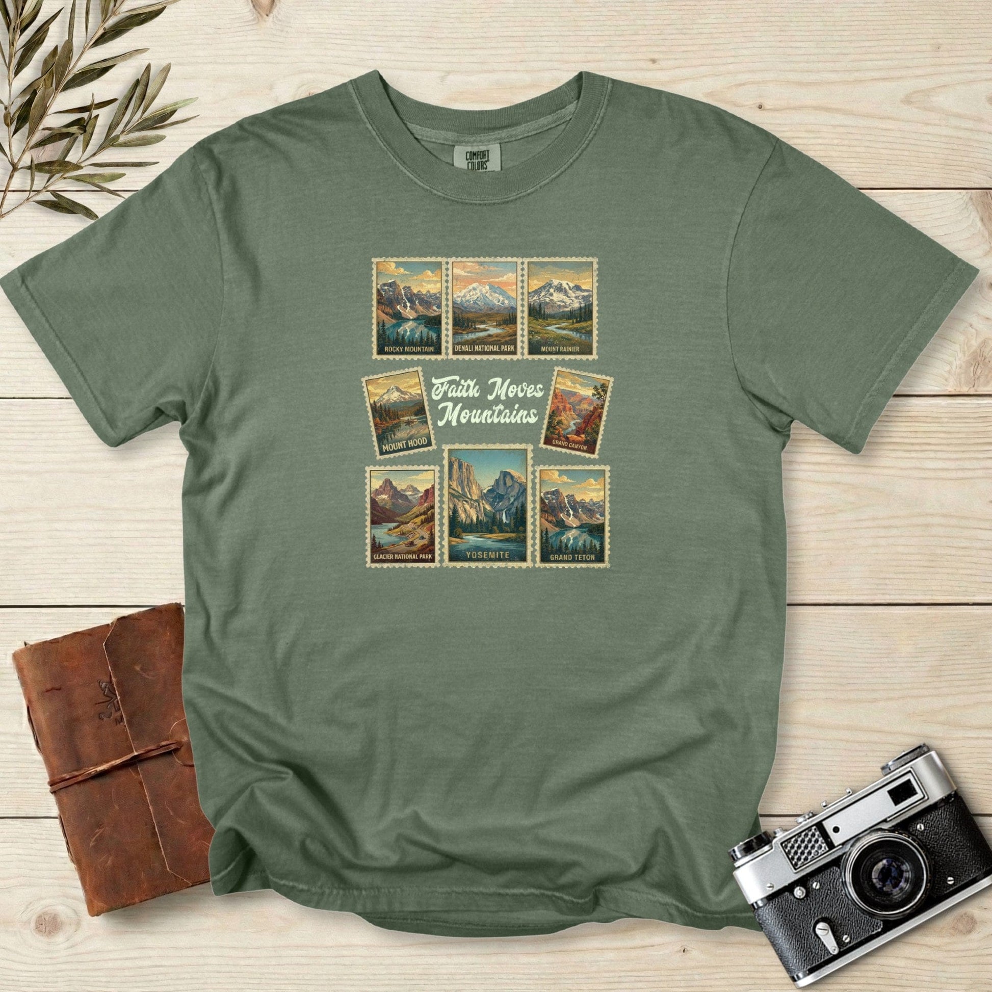 Comfort Colors 1717 moss Christian women tee showcasing vintage national park stamps and the message ‘Faith Moves Mountains.’ Outdoor travel themed Christian tshirt for US faith wear and adventure enthusiasts.