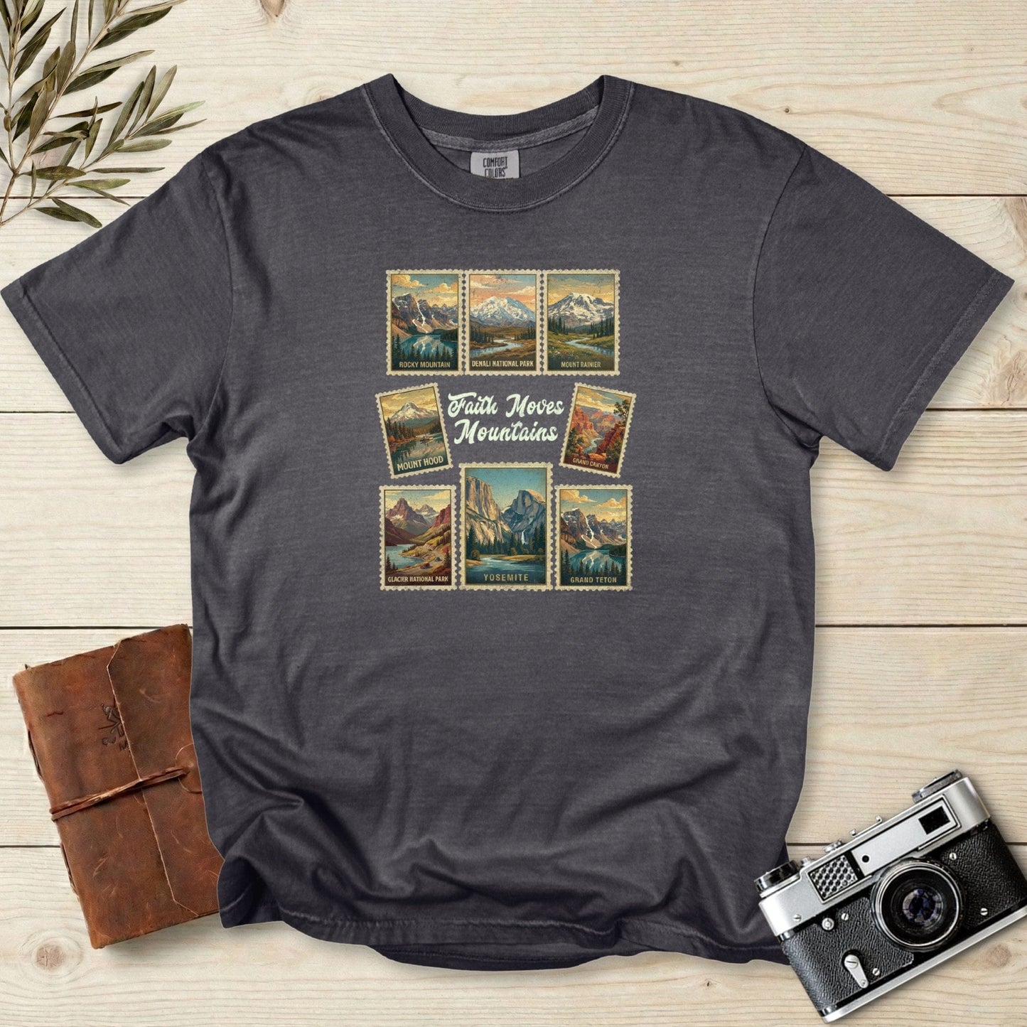 Comfort Colors 1717 pepper Christian women tee featuring a vintage travel-stamp design with US national parks and the phrase ‘Faith Moves Mountains.’ Soft outdoor-inspired Christian tshirt perfect for faith wear and adventure lover