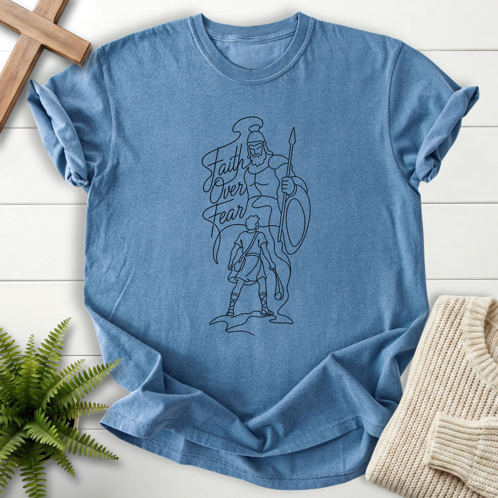 Flatlay of a Blue Jean faith-based tee with script typography with "Faith Over Fear David vs Goliath T-Shirt".