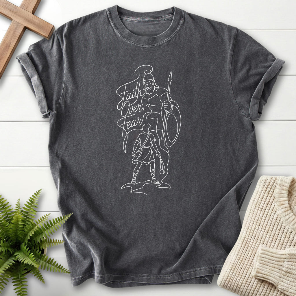 Flat lay of a Pepper Comfort Colors 1717 faith-inspired shirt featuring script typography with "Faith Over Fear David vs Goliath T-Shirt".