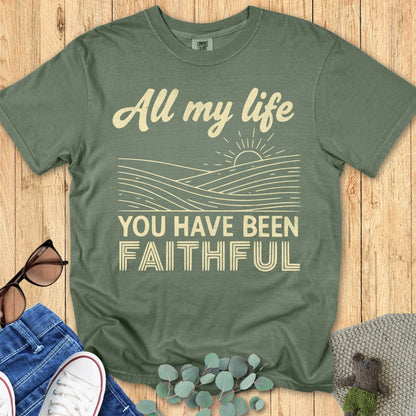 Comfort Colors 1717 Christian women t-shirt in moss green flat lay on wood background. Design reads “All my life you have been faithful” with sun and waves illustration in vintage cream print