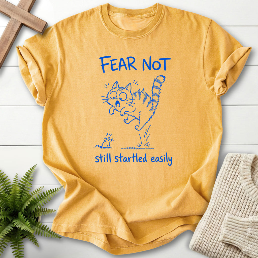 Flatlay of a Mustard Comfort Colors 1717 garment-dyed Christian tee with "Fear Not Still Startled Easily T-Shirt" design.