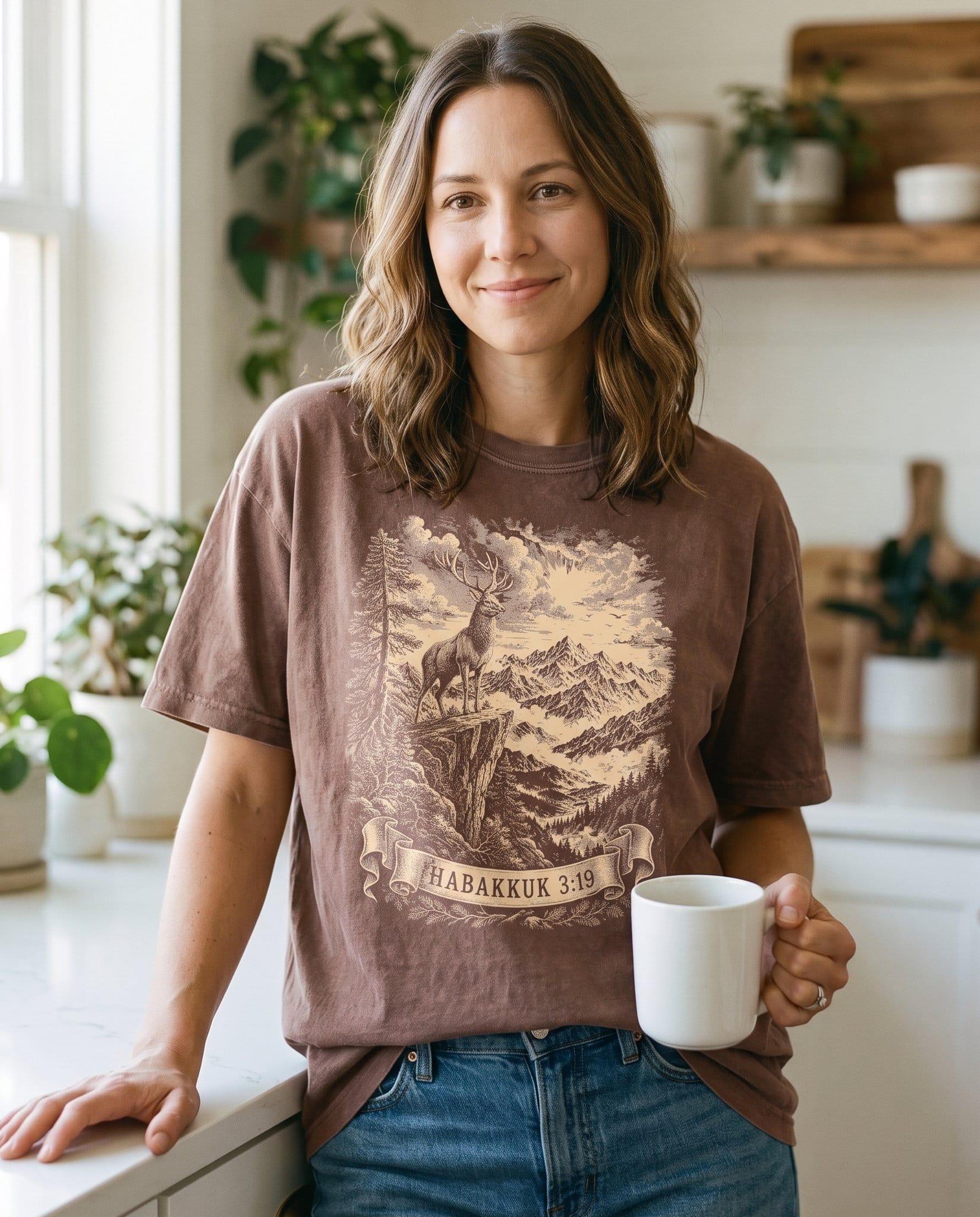 Feet of a Deer – Espresso women's Christian tee, lifestyle photo in morning kitchen setting – Engraved-style stag standing watch on a rocky cliff over the wildernes – Habakkuk 3:19 – She Wears Faith