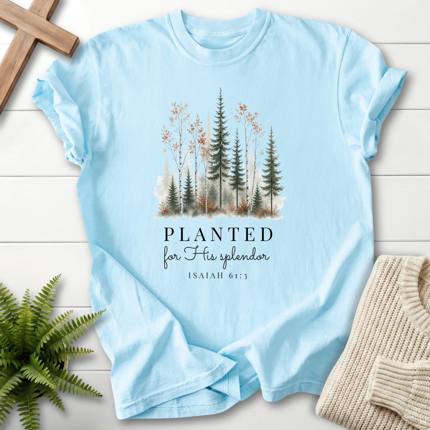 Flat lay of a Chambray women's Christian tee featuring watercolor artwork with "Planted for His Splendor T-Shirt" Isaiah 61:3.