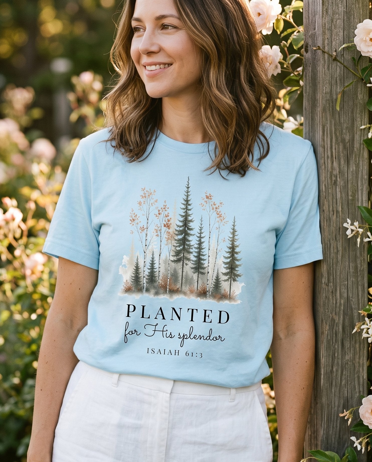Planted for His Splendor – Chambray women's Christian tee, lifestyle photo in outdoor garden – Watercolor forest of evergreen pines and autumn birch trees rising fro – Isaiah 61:3 – She Wears Faith