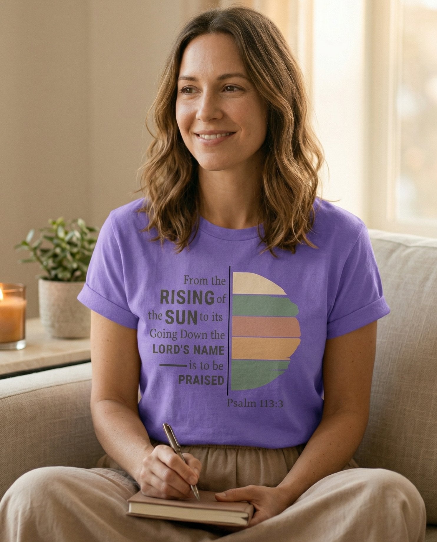 From the Rising of the Sun – Violet women's Christian tee, lifestyle photo in cozy living room – Modern typographic design with a half-sun in retro earth tones split i – Psalm 113:3 – She Wears Faith