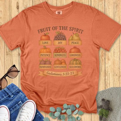 Flatlay of a Comfort Colors 1717 yam “Fruit of the Spirit” t-shirt featuring fall fruit illustrations like pumpkins, pears, and grapes symbolizing Galatians 5:22–23. A cozy women’s scripture tee — faith-based apparel for women and modern Christian shirt, thoughtful Christian mom gift idea for autumn.