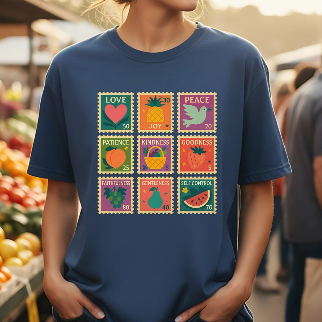 Woman wearing a navy Comfort Colors Christian T-shirt with a colorful Fruit of the Spirit stamp design featuring love, joy, peace, patience, kindness, goodness, faithfulness, gentleness, and self-control.