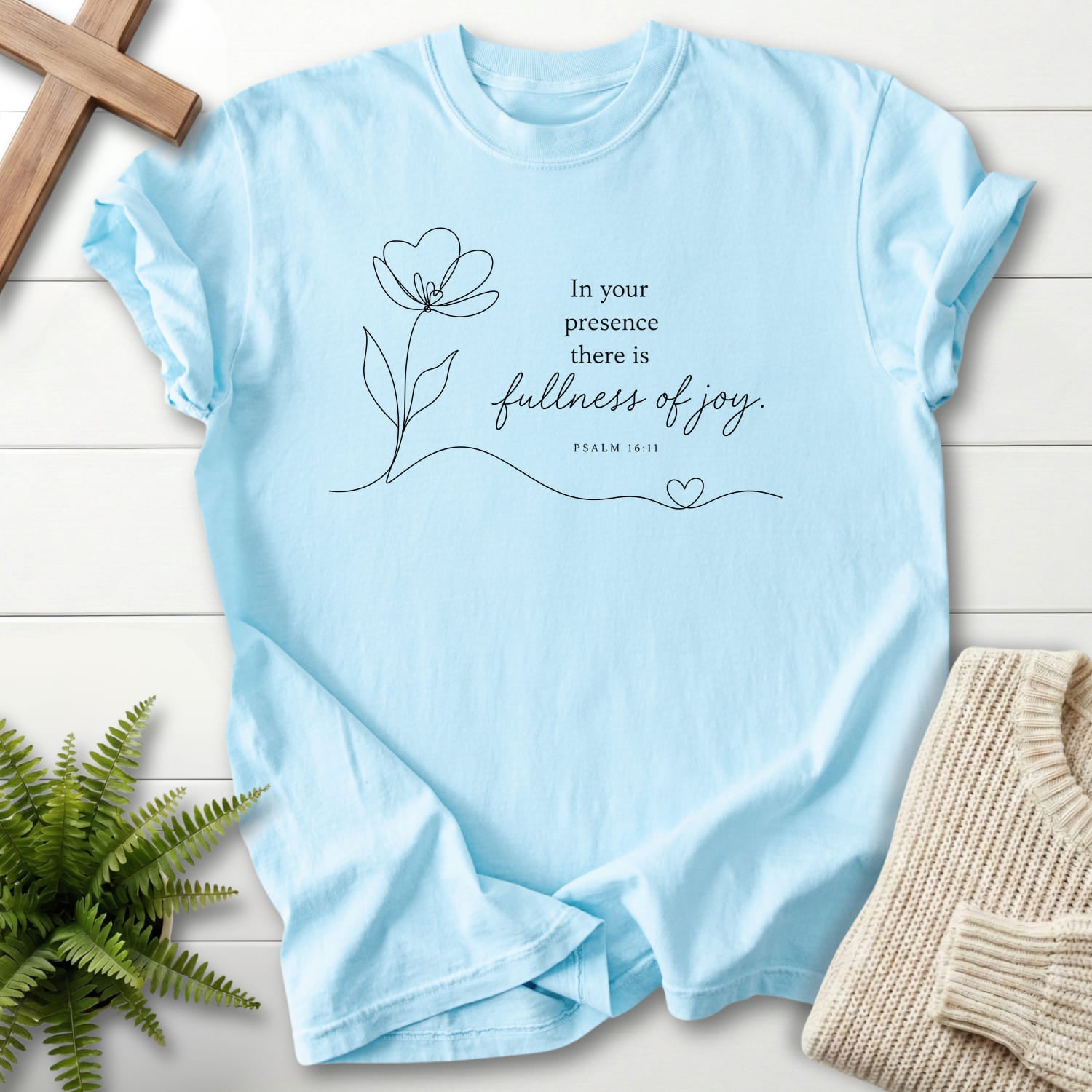 Flatlay of a Chambray Christian shirt with flower artwork with "Fullness of Joy T-Shirt" Psalm 16:11.