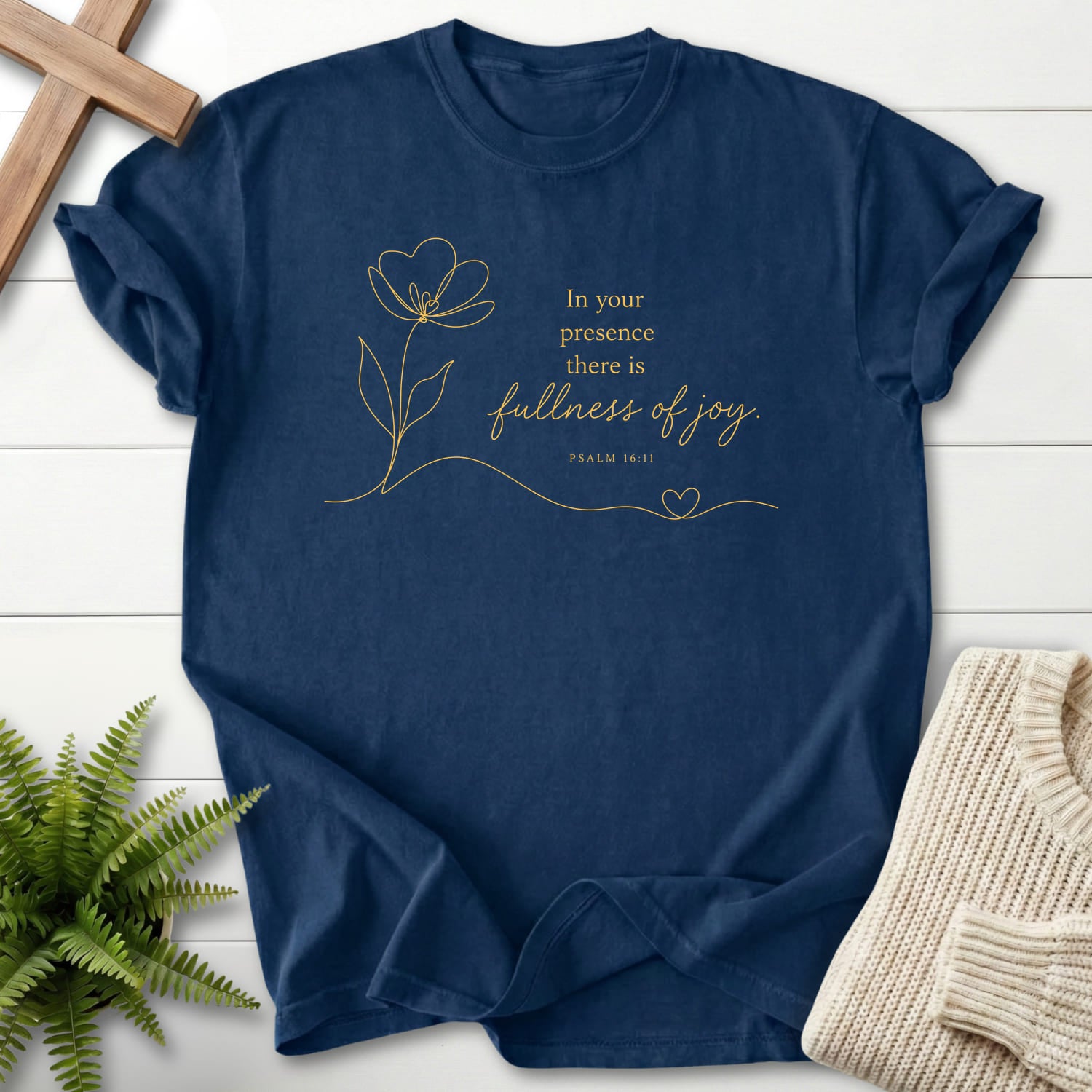 Flatlay of a Navy Scripture shirt with flower artwork with "Fullness of Joy T-Shirt" Psalm 16:11.