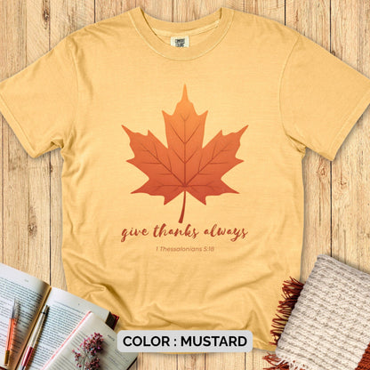 Christian women’s shirt featuring “Give Thanks Always – 1 Thessalonians 5:18” on a Comfort Colors 1717 tee, styled on a cozy flatlay with Bible, pen, and blanket for a faith-inspired fall look.
