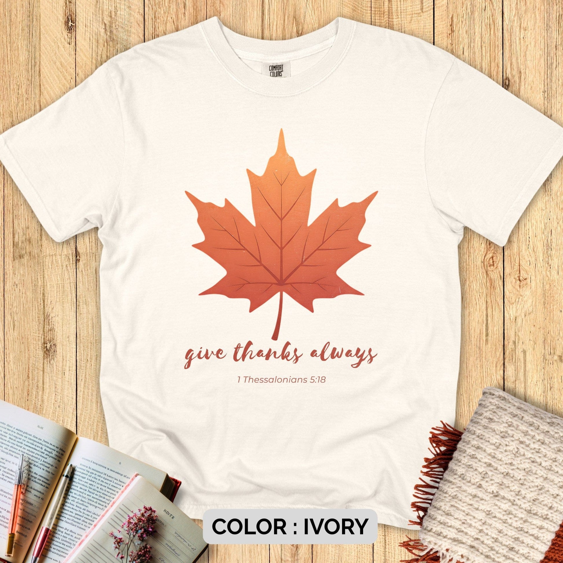 “Give Thanks Always” Comfort Colors 1717 tee for Christian women, styled flat on wood background with Bible, pens, and knitted throw for a peaceful fall aesthetic.
