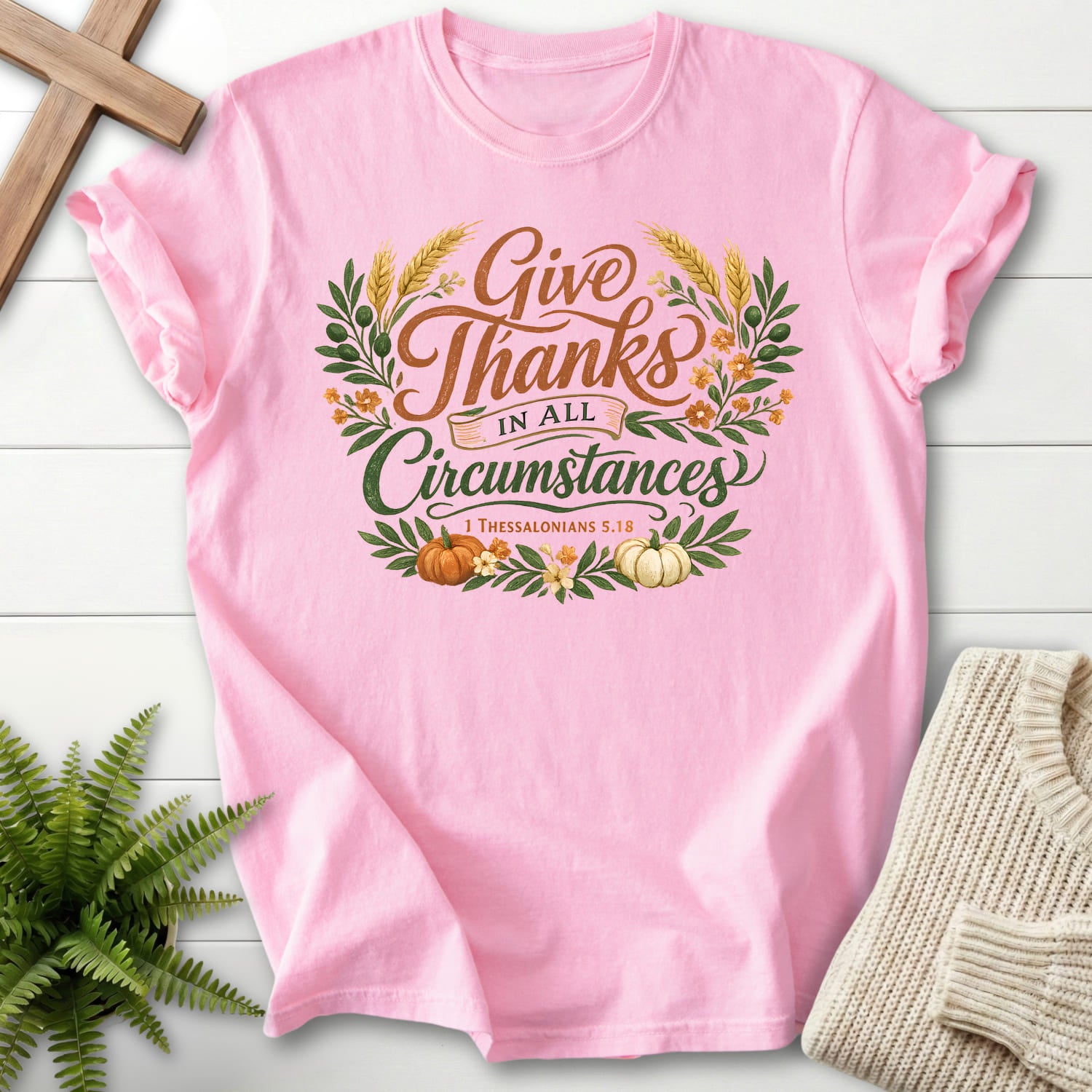Flatlay of a Blossom women's Christian tee with script typography with "Give Thanks in All Circumstances T-Shirt" 1 Thessalonians 5:18.