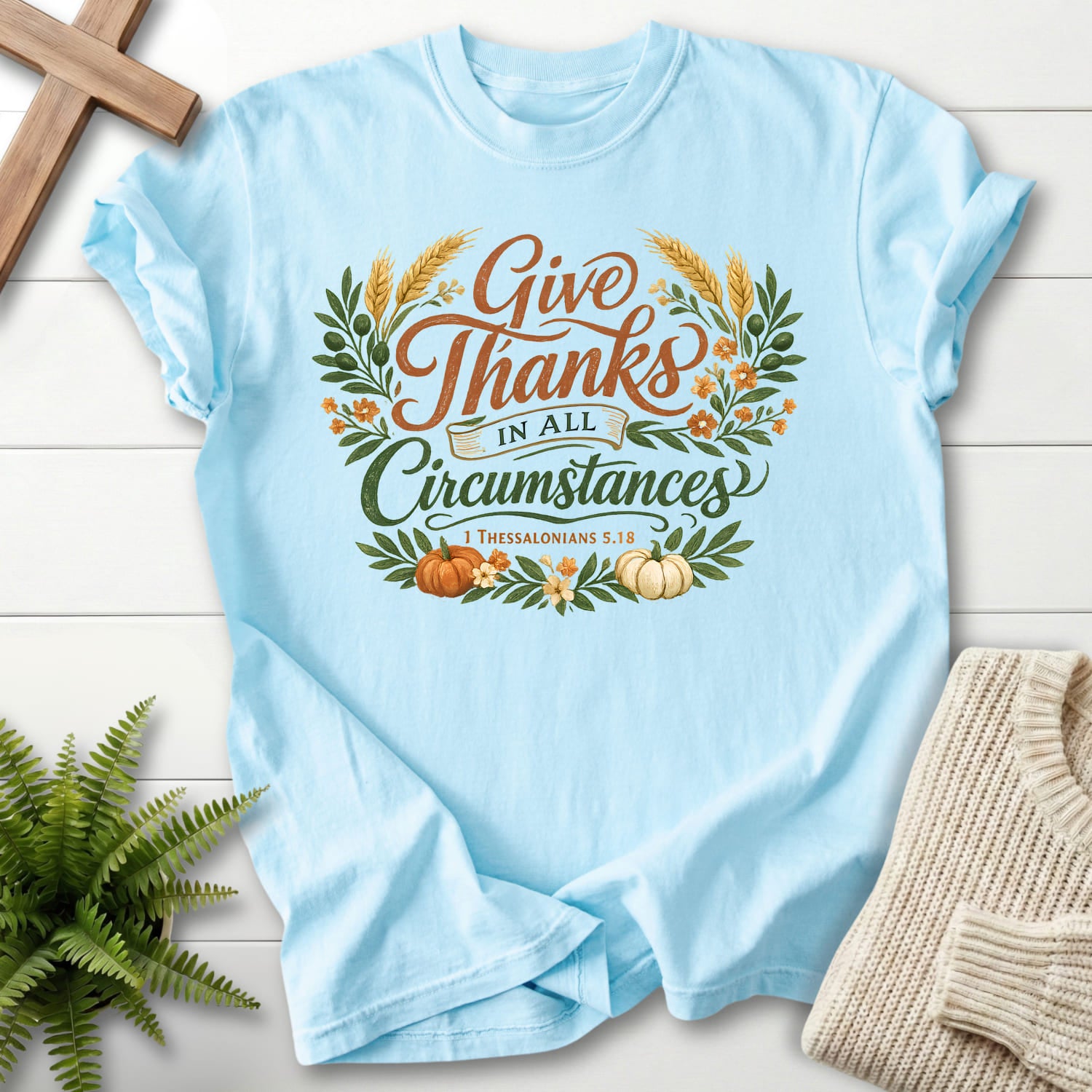 Flat lay of a Chambray Christian shirt featuring script typography with "Give Thanks in All Circumstances T-Shirt" 1 Thessalonians 5:18.