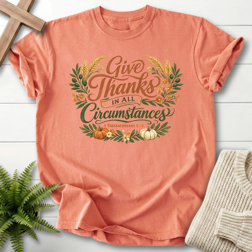 Flat lay of a Terracotta Scripture shirt featuring script typography with "Give Thanks in All Circumstances T-Shirt" 1 Thessalonians 5:18.
