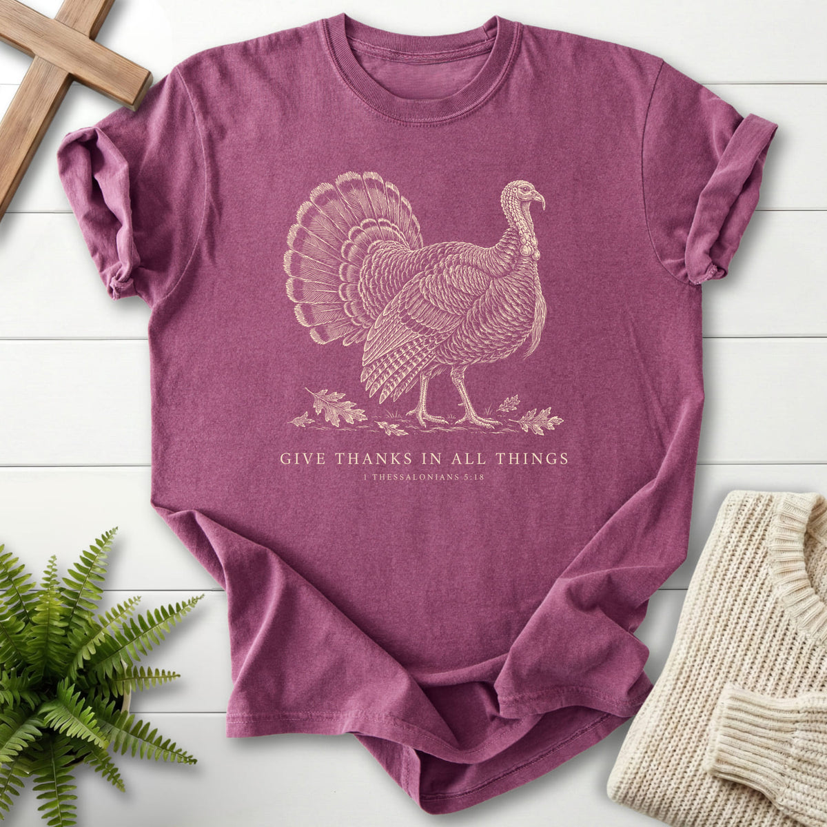 Flat lay of a Berry Christian graphic tee featuring "Give Thanks in All Things Turkey T-Shirt" 1 Thessalonians 5:18.