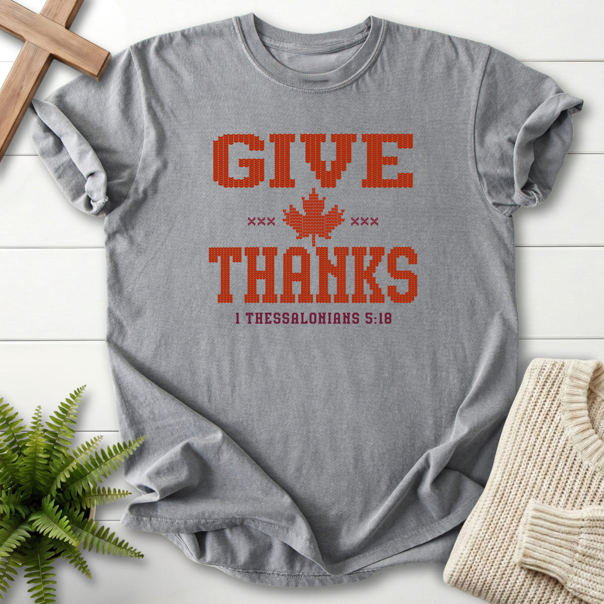 Flatlay of a Grey Comfort Colors 1717 Christian shirt with "Give Thanks Maple Leaf T-Shirt" 1 Thessalonians 5:18.