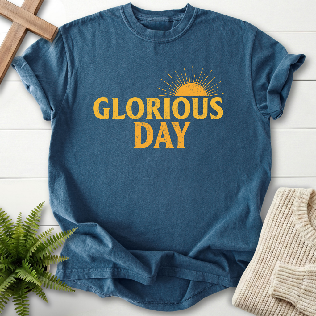 Midnight blue women's faith t-shirt with bold golden 'Glorious Day' lettering and a retro sunrise graphic.