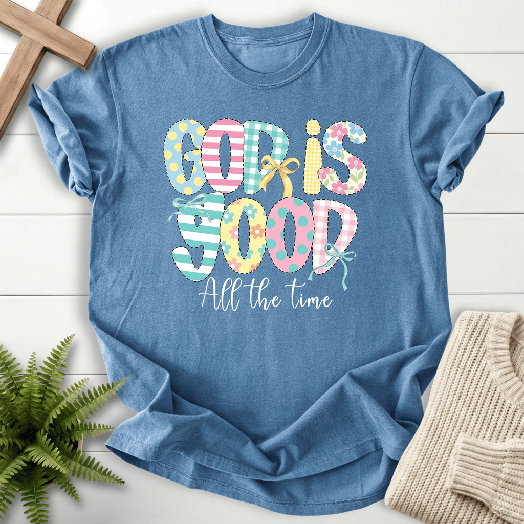 Blue Jean women's faith t-shirt with patchwork pastel 'God Is Good All the Time' lettering featuring stripes, dots, and a bow.