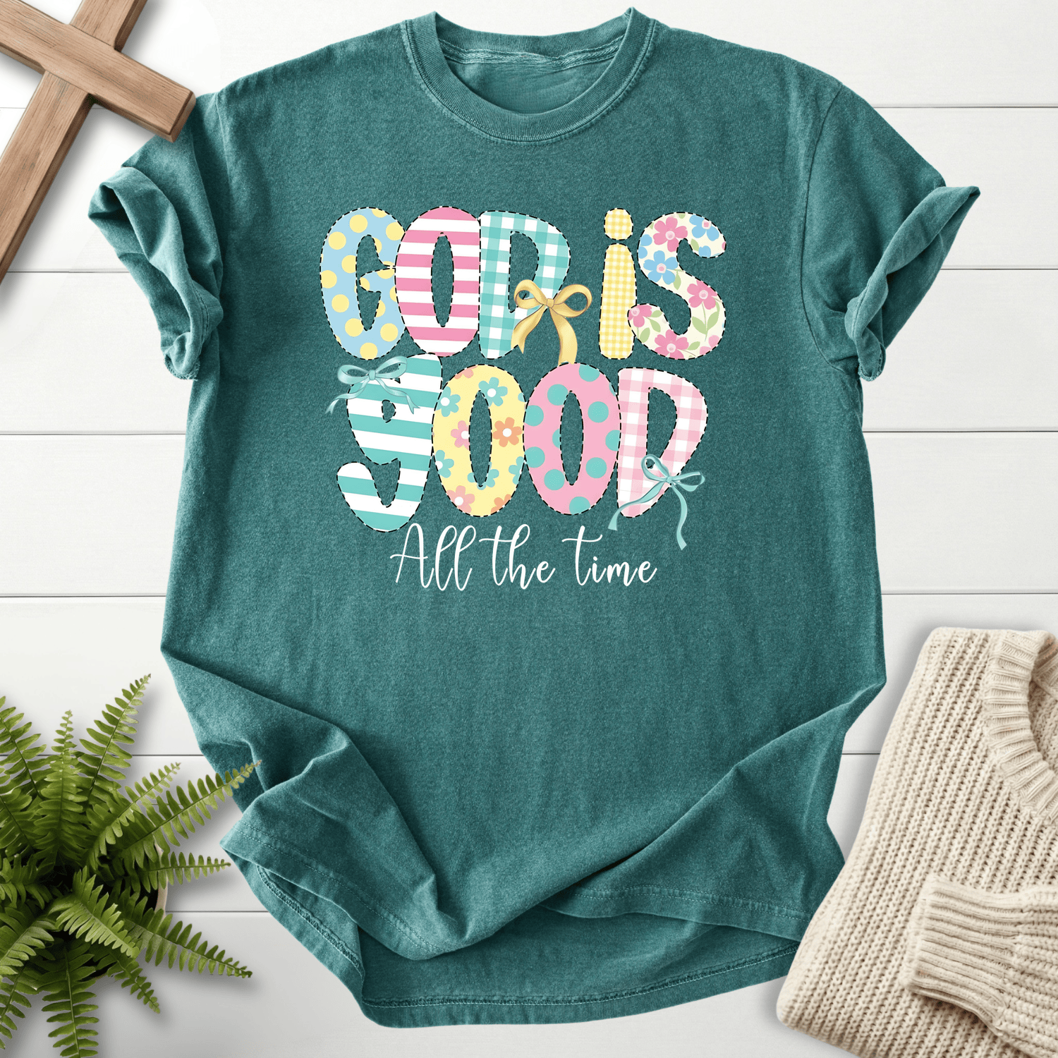 Blue Spruce women's faith t-shirt with a patchwork 'God Is Good All The Time' graphic and ribbon bow, Comfort Colors 1717.