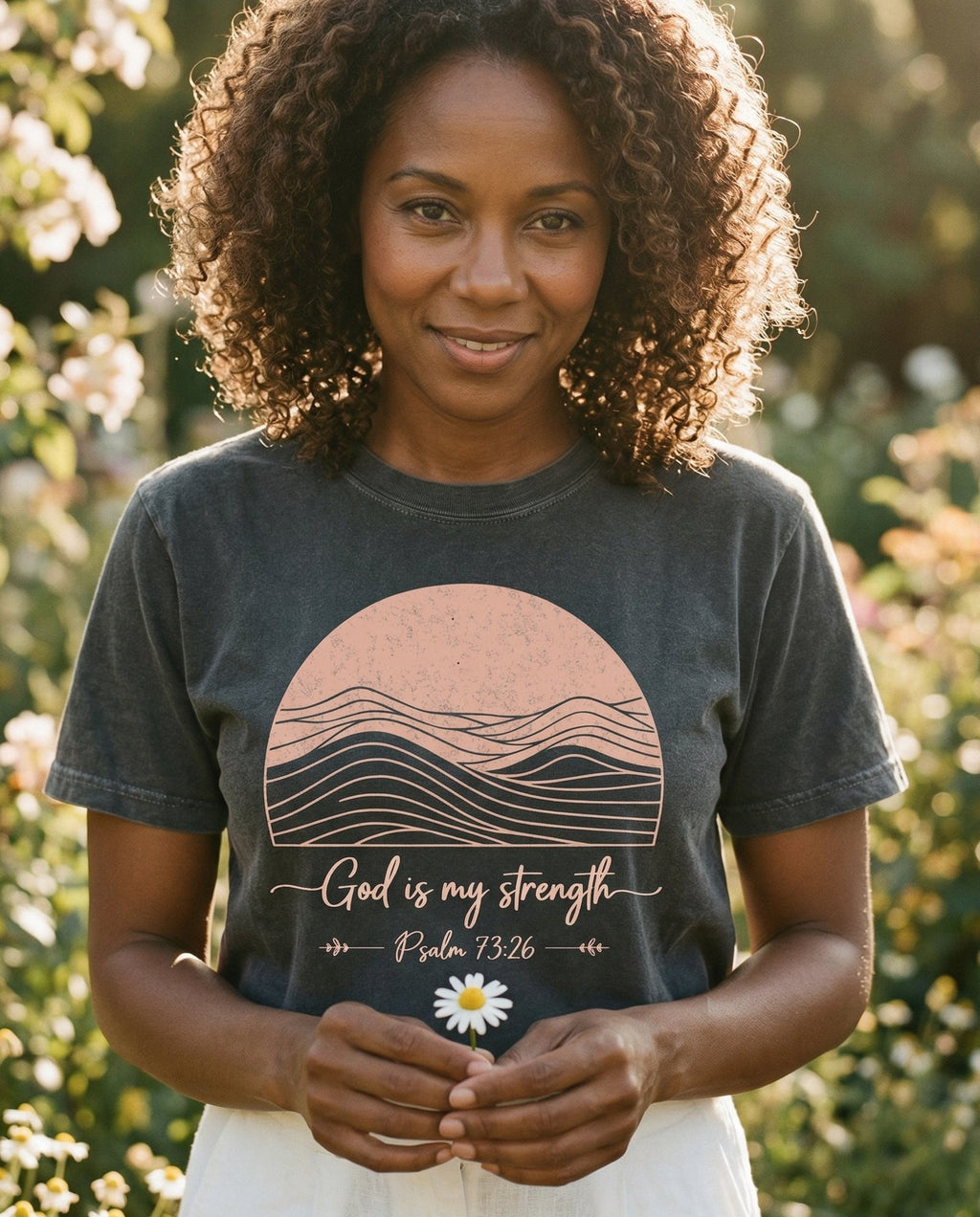 God is My Strength Ps 73:26 – Pepper women's Christian tee, lifestyle photo in outdoor garden – Minimalist mountain landscape with line art wavy peaks inside a semici – Psalm 73:26 – She Wears Faith