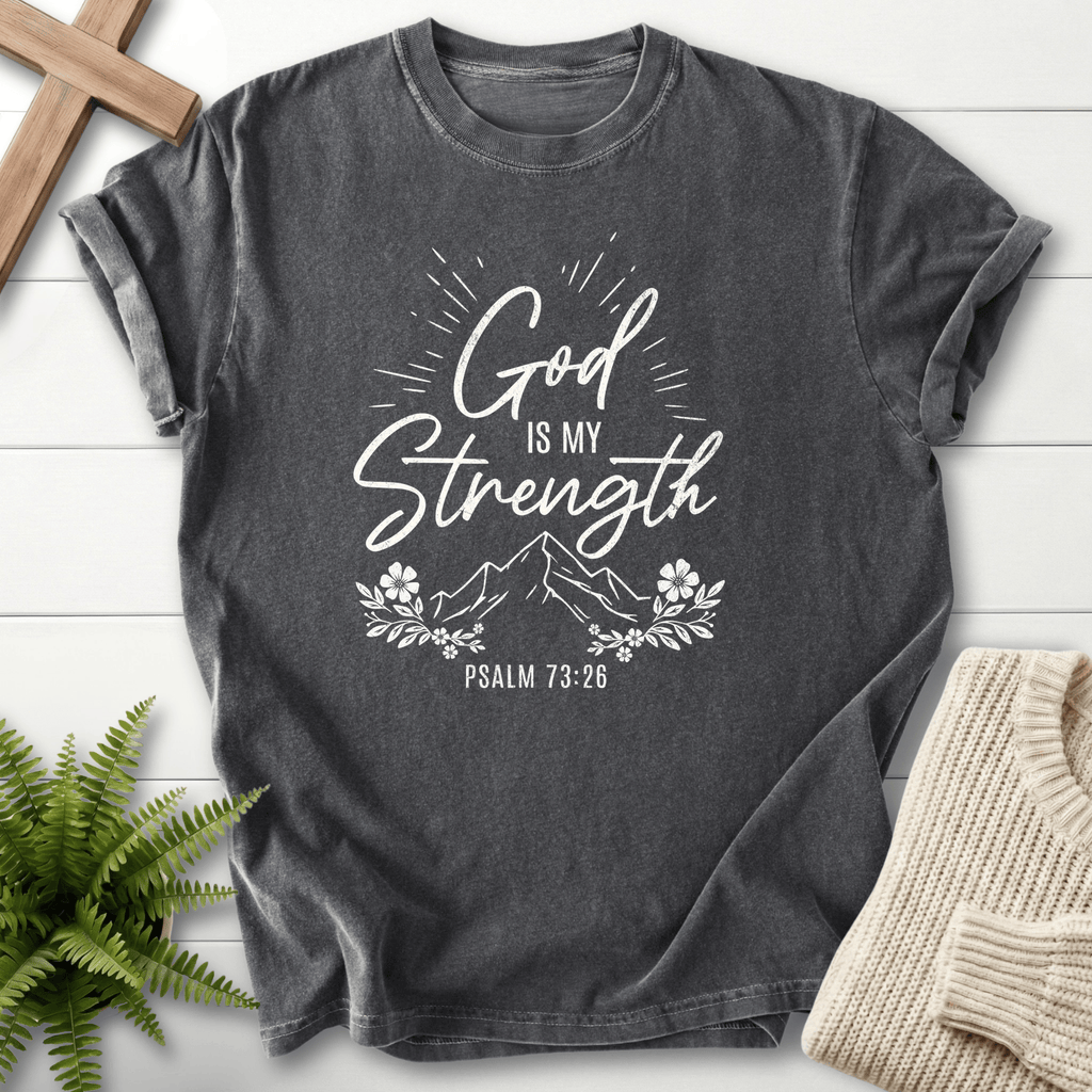 Pepper women's faith t-shirt with bright white 'God Is My Strength' script and a mountain floral design, inspired by Psalm 73:26.