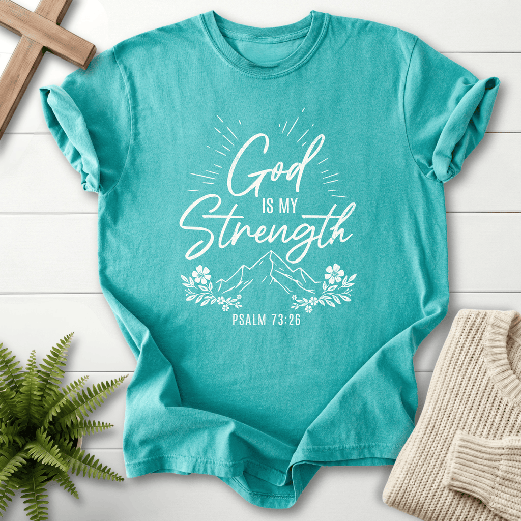 Seafoam Bible verse tee with 'God Is My Strength', a light burst, and floral sprigs, inspired by Psalm 73:26.