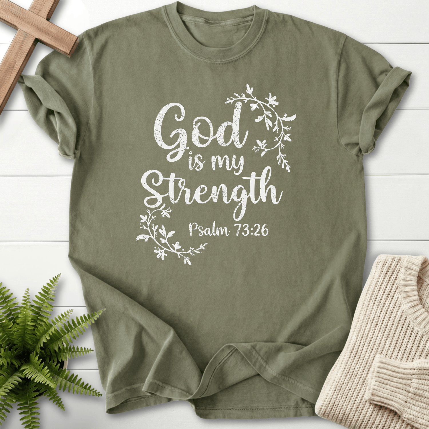 Sage Bible verse tee with a botanical vine and leaf motif surrounding 'God is my Strength', inspired by Psalm 73:26.