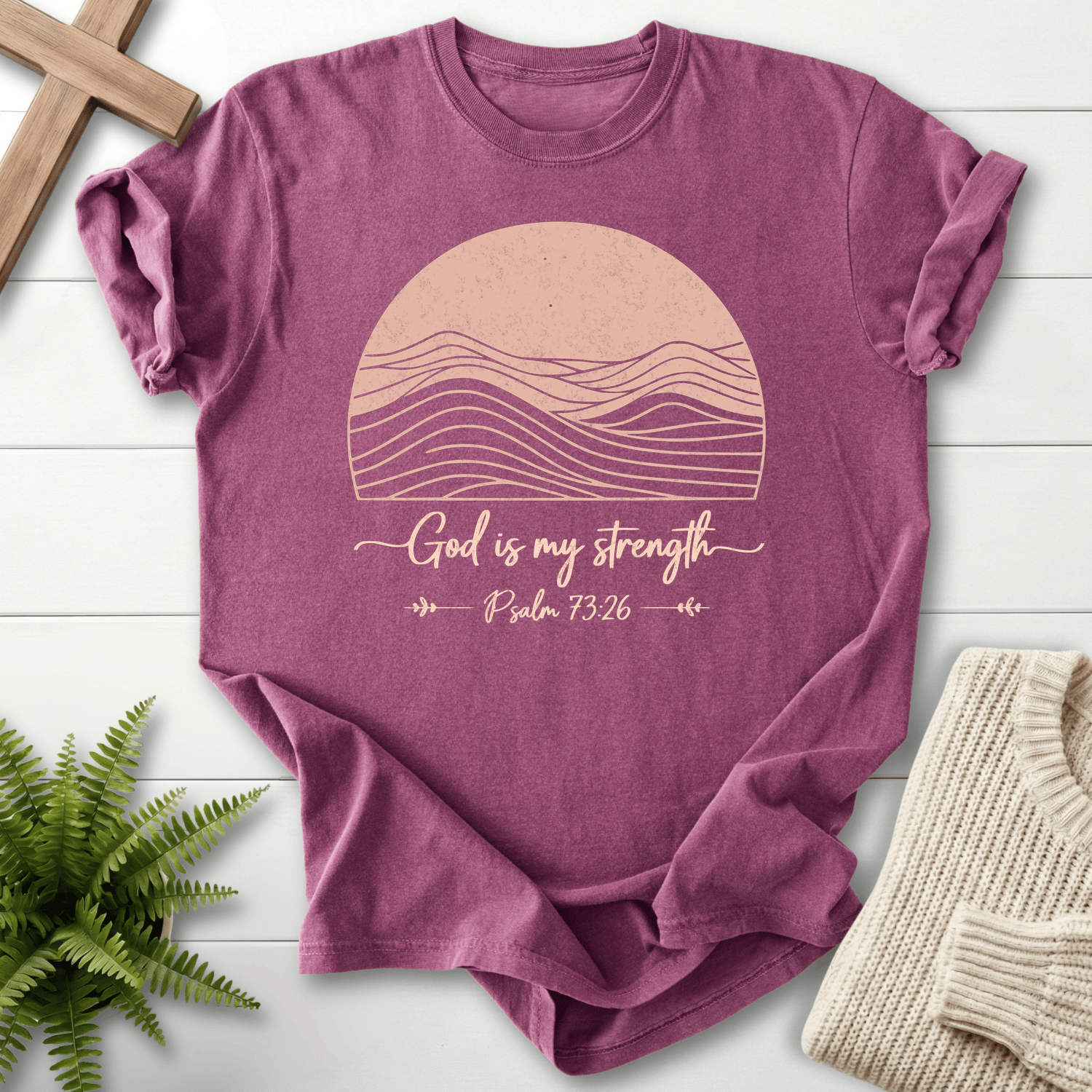 Berry Bible verse tee with a minimalist mountain-in-sun design and 'God is My Strength', inspired by Psalm 73:26.