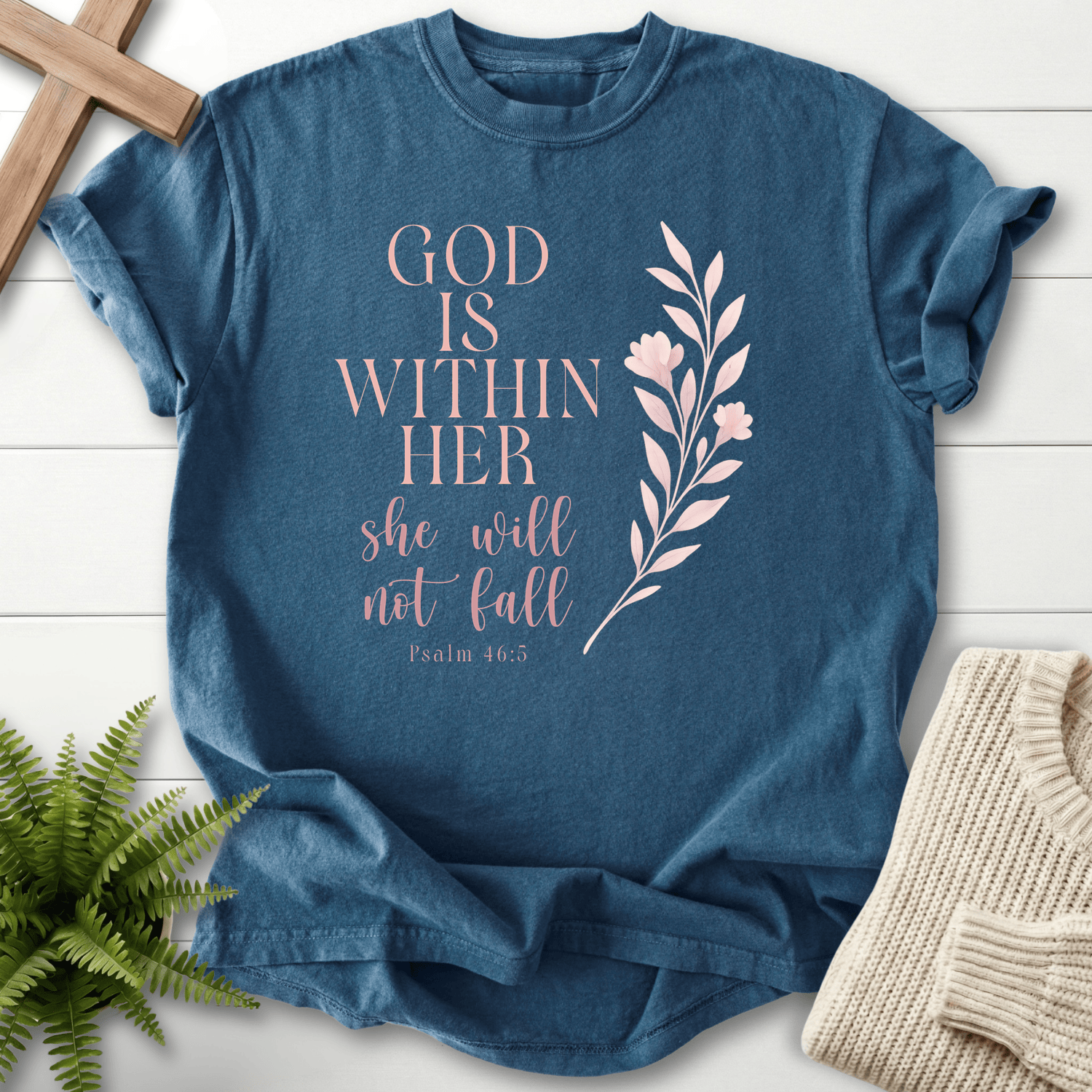 Midnight blue Bible verse tee with 'God is Within Her, She Will Not Fall' and a botanical floral stem, inspired by Psalm 46:5.