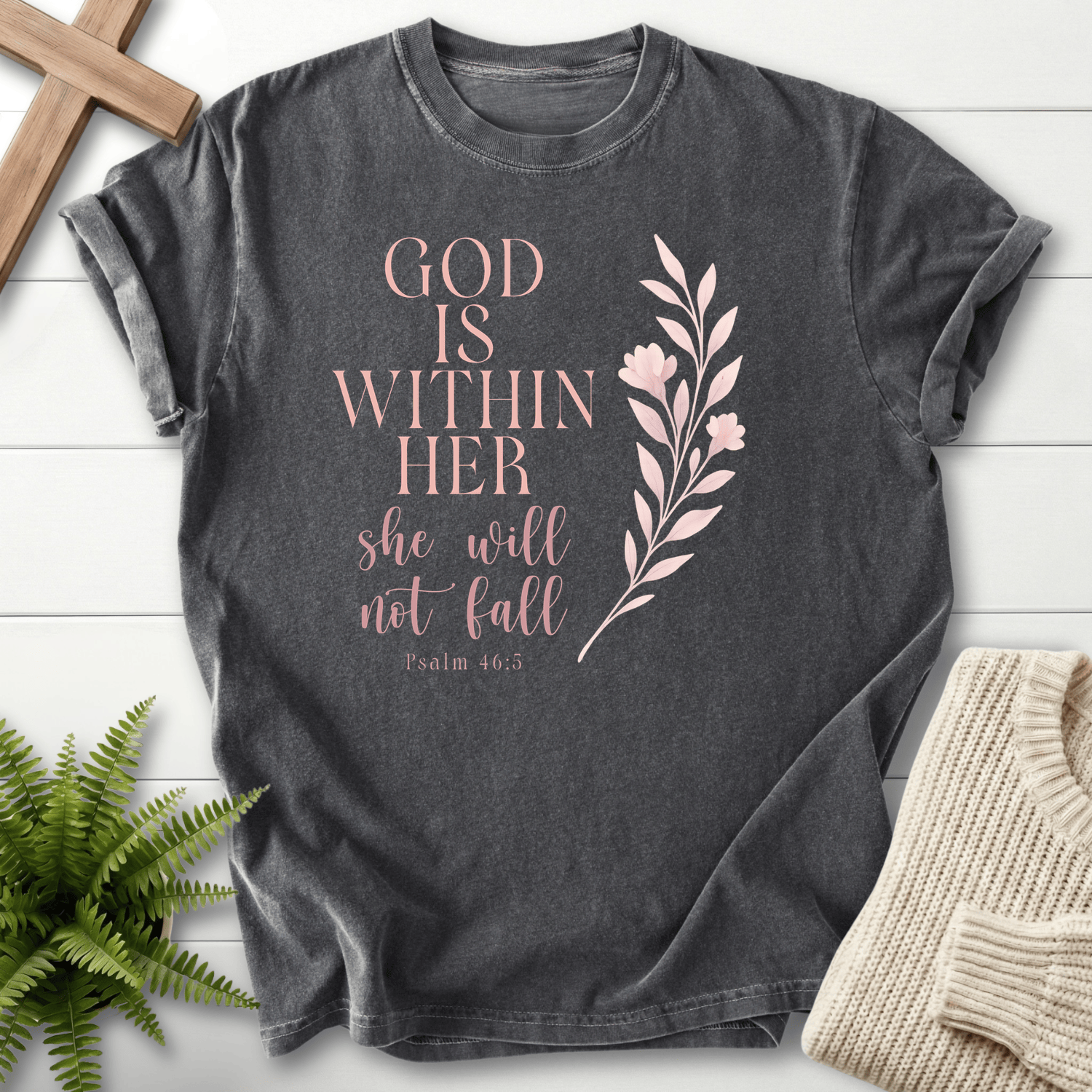 Pepper women's faith t-shirt with 'God is Within Her, She Will Not Fall' and a botanical leaf accent, inspired by Psalm 46:5.