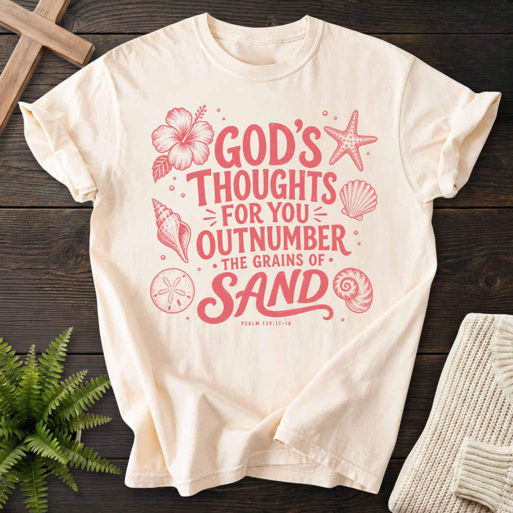 Flat lay of an Ivory Comfort Colors 1717 faith-inspired shirt featuring flower artwork with "God's Thought For You Outnumber T-Shirt" Psalm 139:17-18.