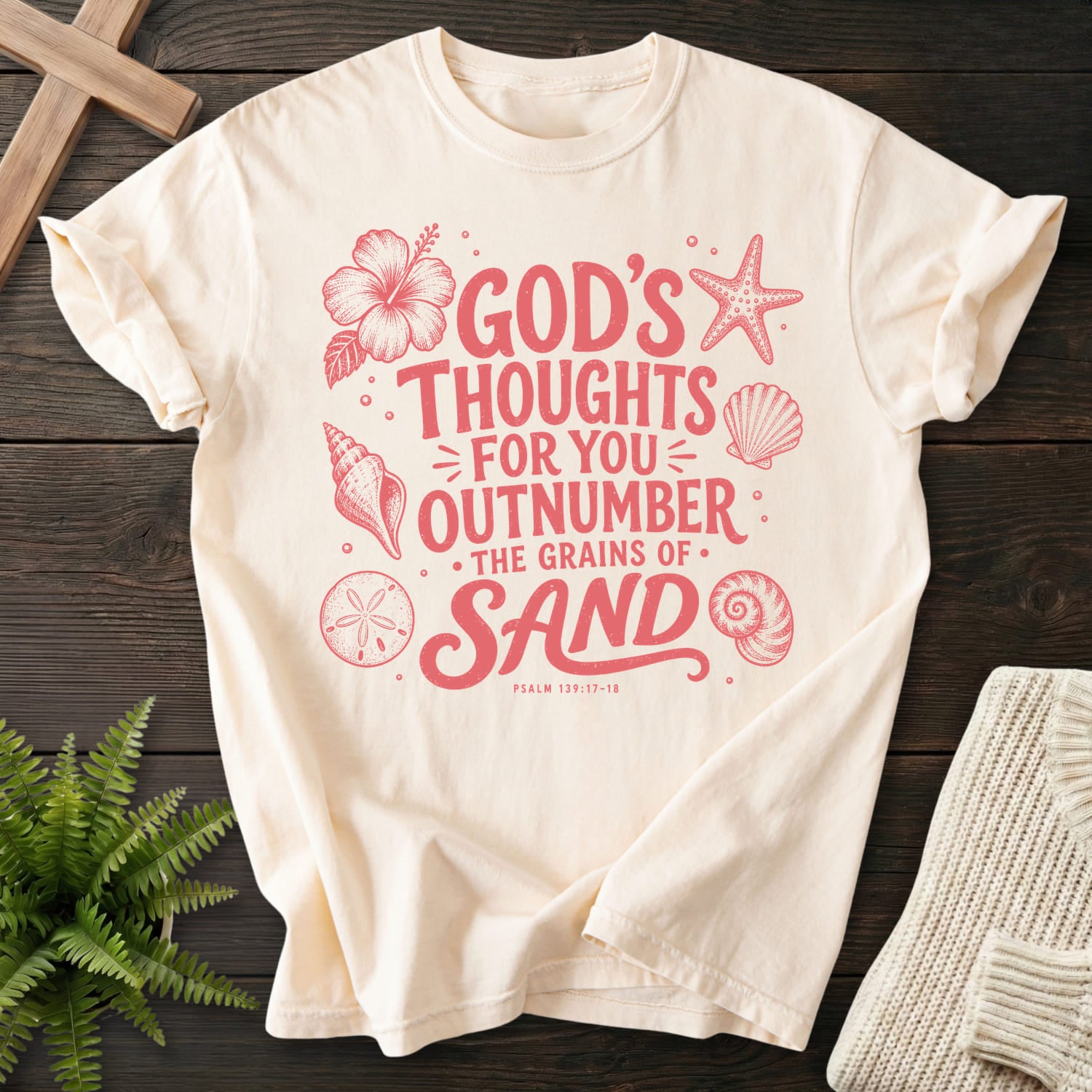 Flat lay of an Ivory Comfort Colors 1717 faith-inspired shirt featuring flower artwork with "God's Thought For You Outnumber T-Shirt" Psalm 139:17-18.