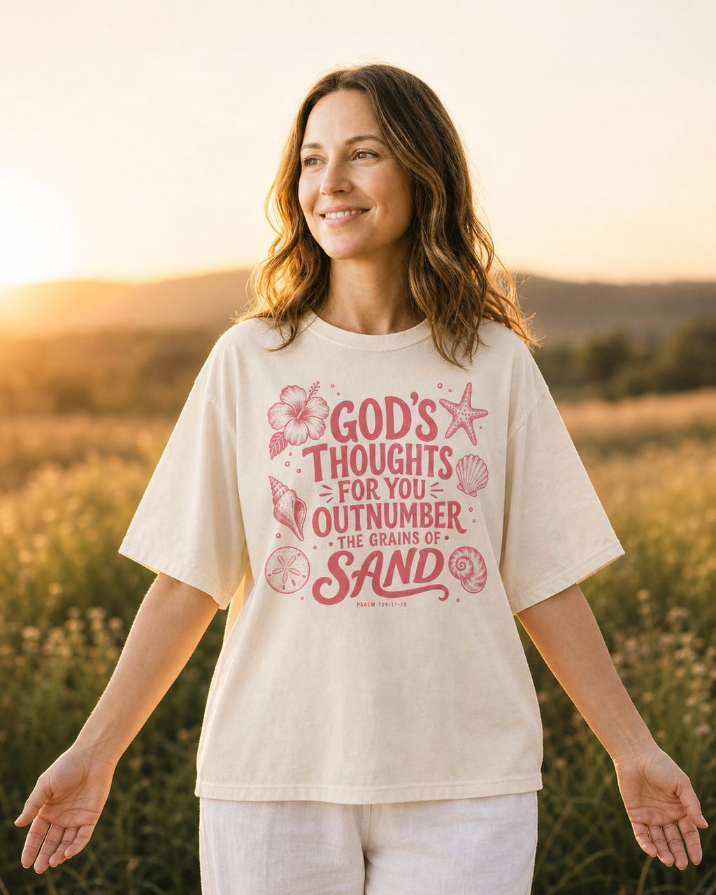 God's Thought For You – Ivory women's Christian tee, lifestyle photo in wildflower meadow at sunrise – Coral seashells and starfish surrounding hand-lettered type – Psalm 139:17-18 – She Wears Faith