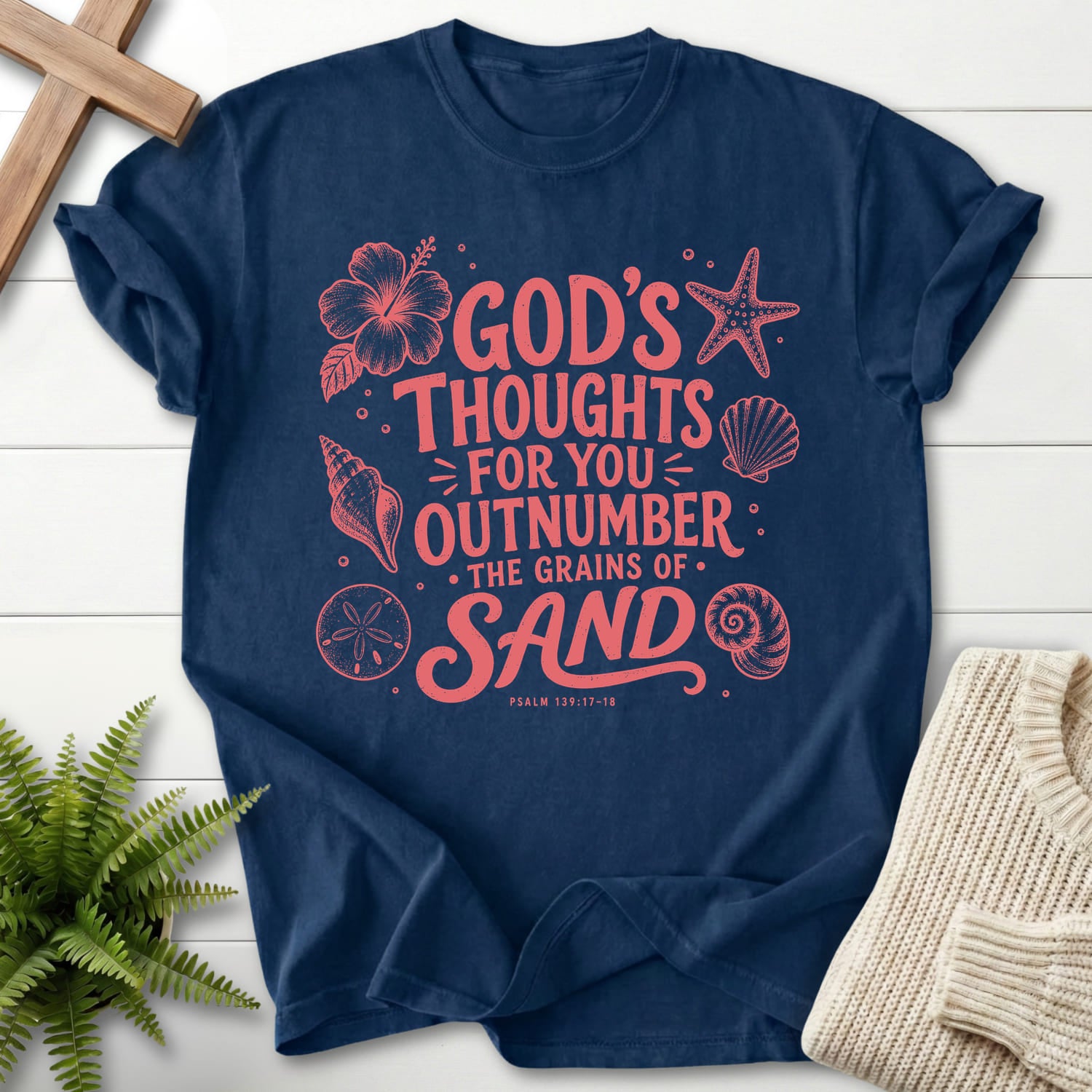 Flatlay of a Navy Christian shirt with flower artwork with "God's Thought For You Outnumber T-Shirt" Psalm 139:17-18.