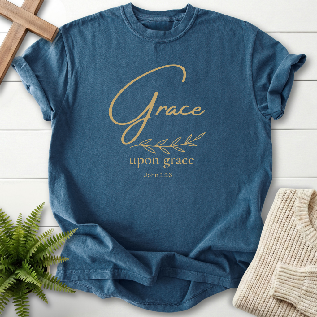 Midnight blue Bible verse tee with gold script 'Grace upon grace' and an olive branch accent, inspired by John 1:16.