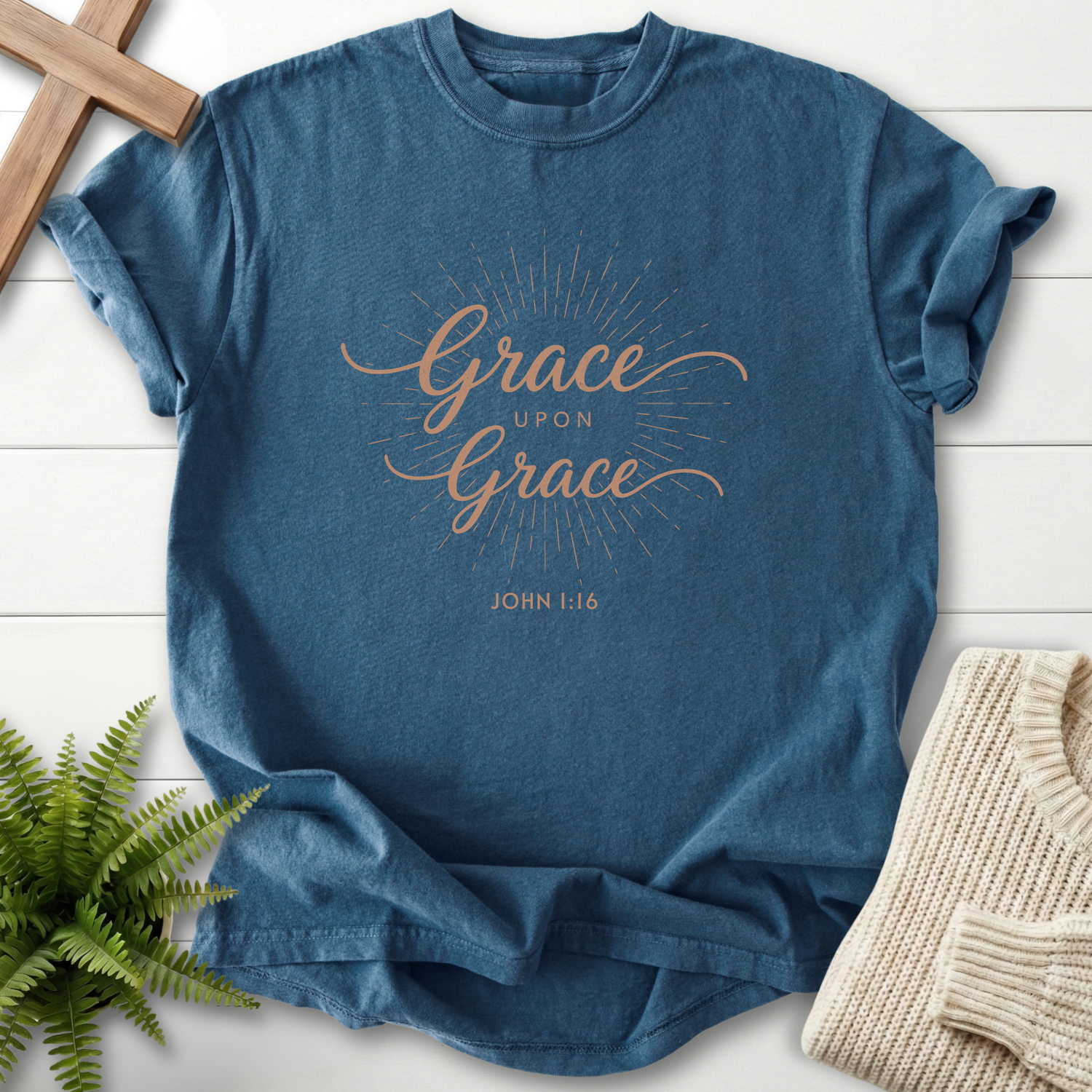 Midnight blue Bible verse tee with radiant 'Grace Upon Grace' script and a sunray halo, inspired by John 1:16.