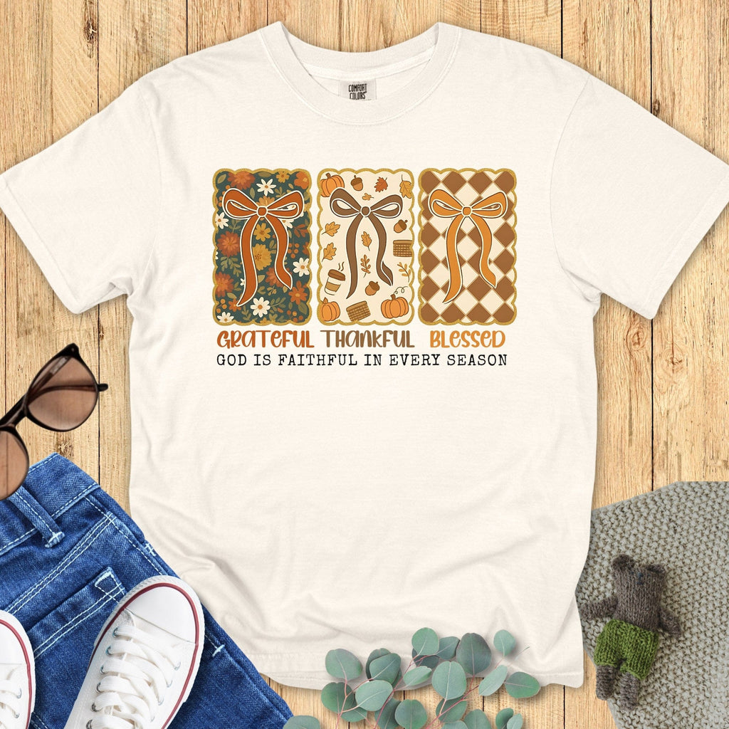 Flatlay of a Comfort Colors 1717 ivory “Grateful Thankful Blessed – God Is Faithful in Every Season” t-shirt featuring retro fall ribbon and floral design. A soft women’s scripture tee - faith-based apparel for women and modern Christian shirt, perfect Christian mom gift idea for autumn gratitude