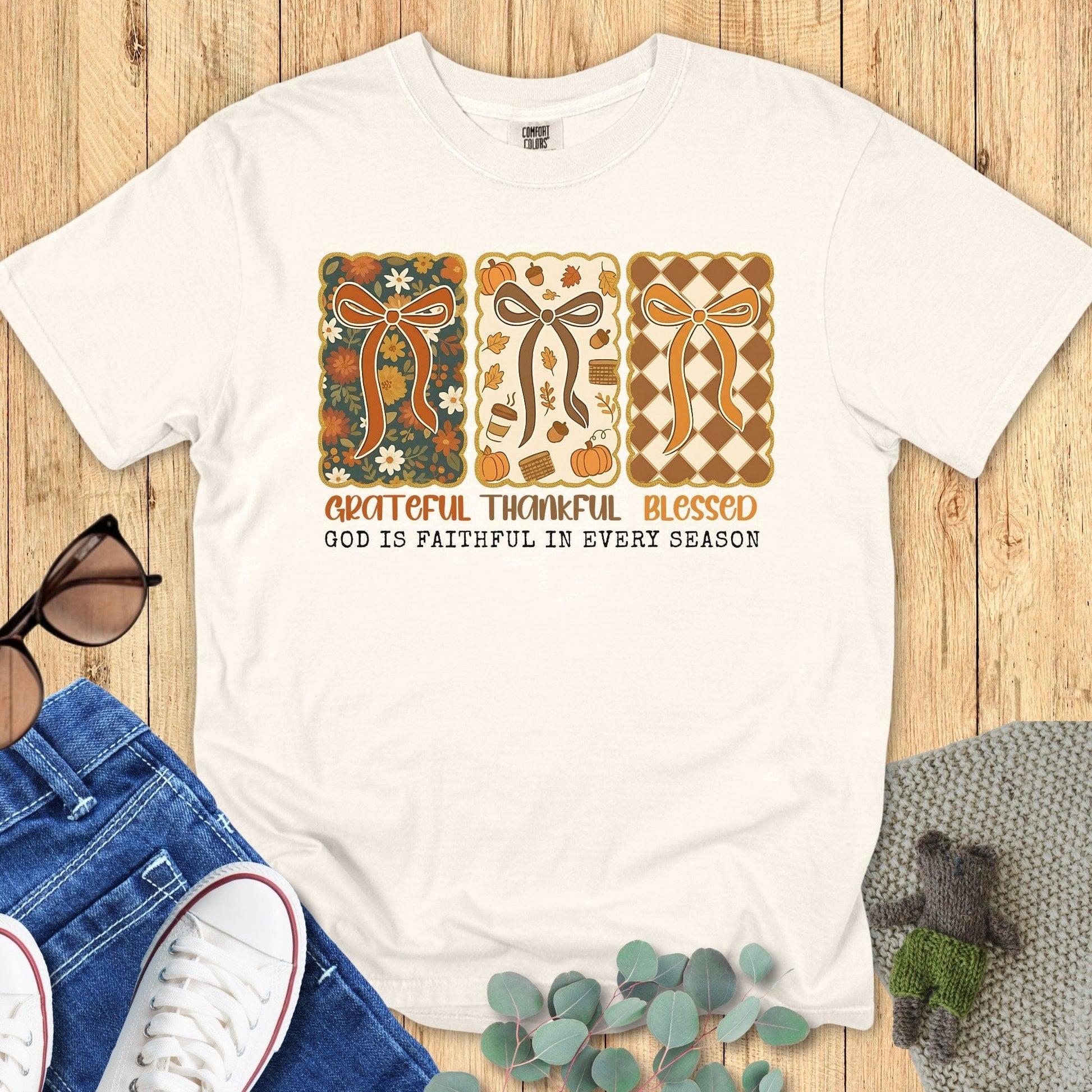 Flatlay of a Comfort Colors 1717 ivory “Grateful Thankful Blessed – God Is Faithful in Every Season” t-shirt featuring retro fall ribbon and floral design. A soft women’s scripture tee - faith-based apparel for women and modern Christian shirt, perfect Christian mom gift idea for autumn gratitude