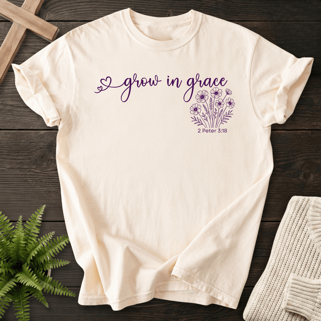 Ivory women's faith t-shirt with a heart accent, 'grow in grace' lettering, and a wildflower cluster, inspired by 2 Peter 3:18.