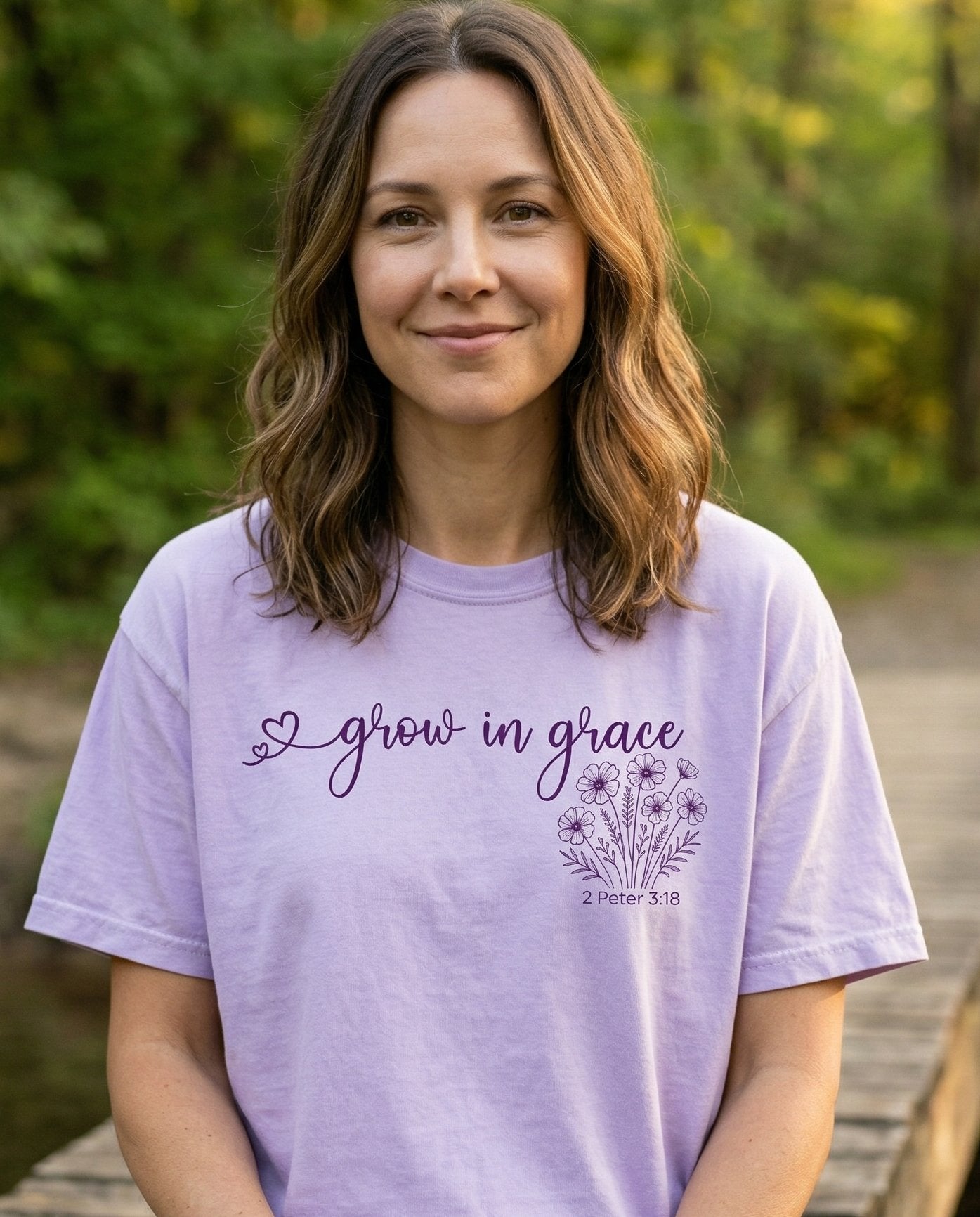Grow in grace wildflower – Orchid women's Christian tee, lifestyle photo in nature trail – Cursive 'grow in grace' with a small heart accent followed by a wildfl – 2 Peter 3:18 – She Wears Faith