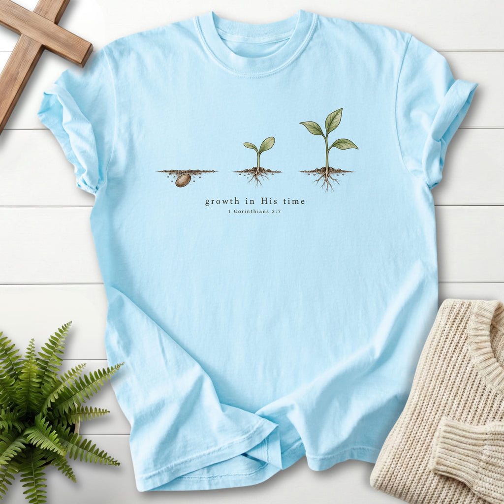 Flat lay of a Chambray Comfort Colors 1717 Christian t-shirt for women featuring "Growth in His Time T-Shirt" 1 Corinthians 3:7.