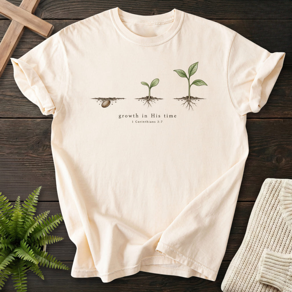 Flatlay of an Ivory faith-based tee with "Growth in His Time T-Shirt" 1 Corinthians 3:7.
