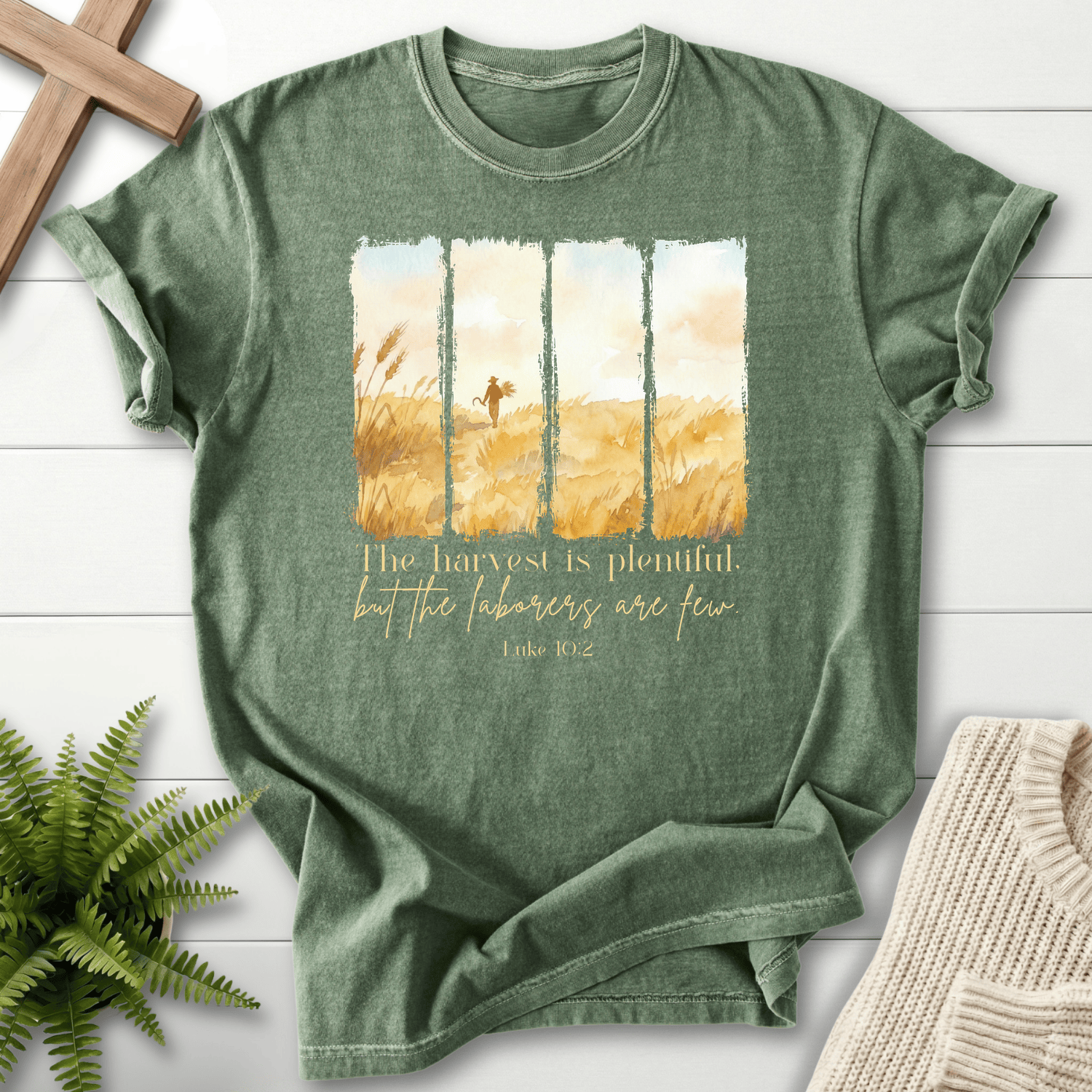 Moss green Bible verse tee with watercolor harvest wheat field panels and 'The harvest is plentiful', inspired by Luke 10:2.