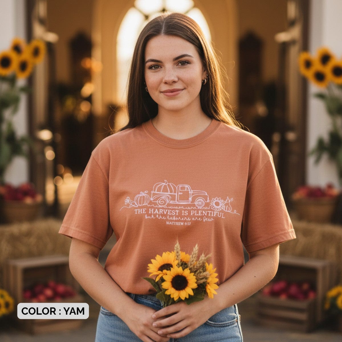 Smiling woman wearing a Comfort Colors 1717 yam “The harvest is plentiful but the laborers are few” t-shirt (Matthew 9:37) while holding sunflowers. A soft women’s scripture tee -  faith-based apparel for women and modern Christian shirt, perfect Christian mom gift idea for fall or harvest season.