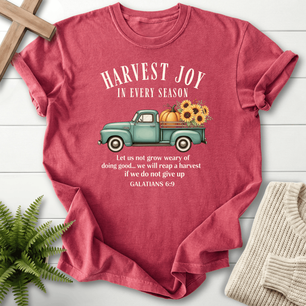Crimson Bible verse tee with an illustrated harvest truck and 'We will reap a harvest if we do not give up', inspired by Galatians 6:9.
