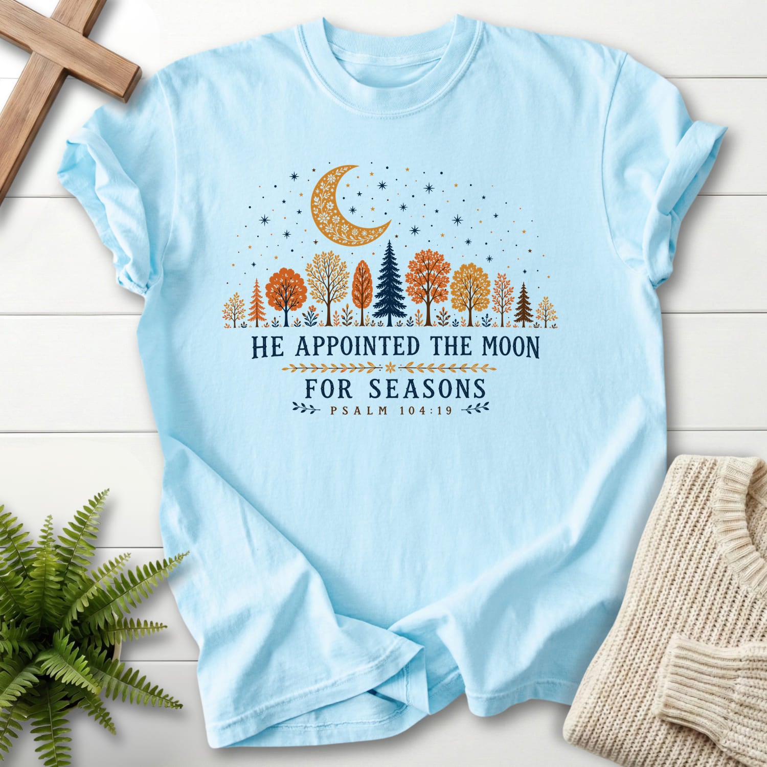 Flatlay of a Chambray Bible verse tee with floral line art with "He Appointed the Moon for Seasons T-Shirt" Psalm 104:19.