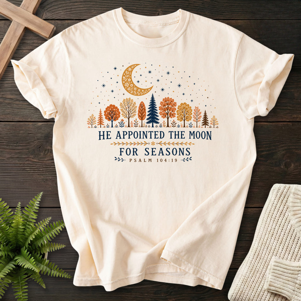 Flat lay of an Ivory garment-dyed Christian tee featuring floral line art with "He Appointed the Moon for Seasons T-Shirt" Psalm 104:19 From Printify.