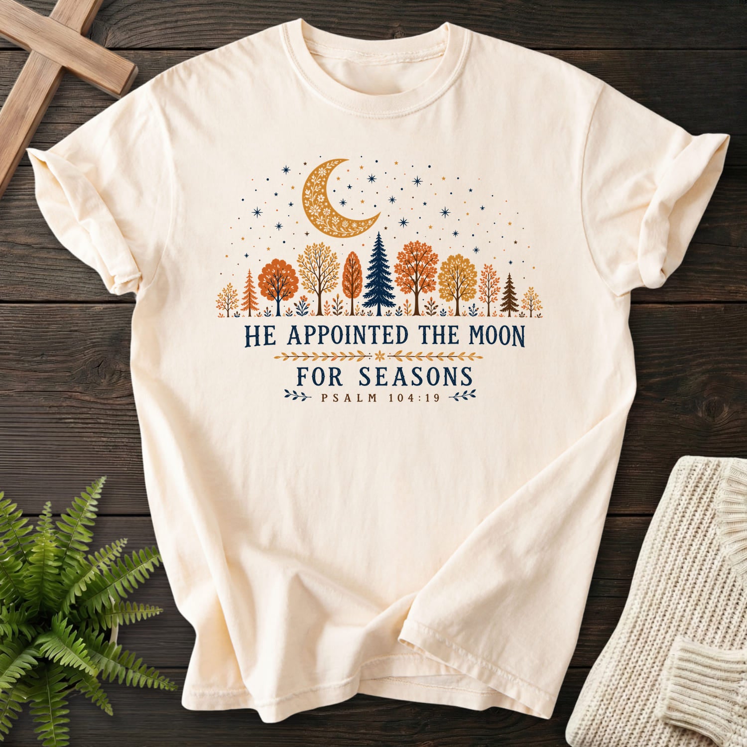 Flat lay of an Ivory garment-dyed Christian tee featuring floral line art with "He Appointed the Moon for Seasons T-Shirt" Psalm 104:19 From Printify.