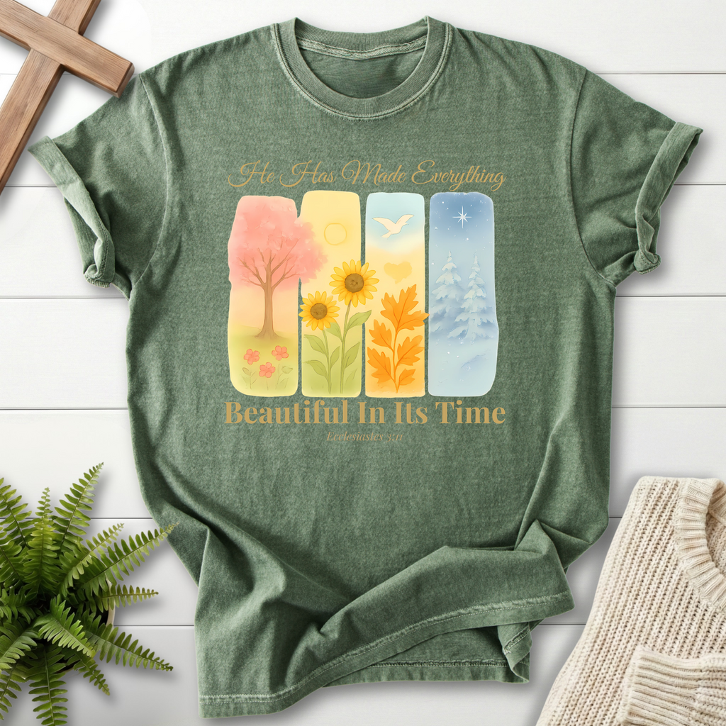 Moss green Bible verse tee with four watercolor panels, a sunflower, and a pine tree, inspired by Ecclesiastes 3:11.
